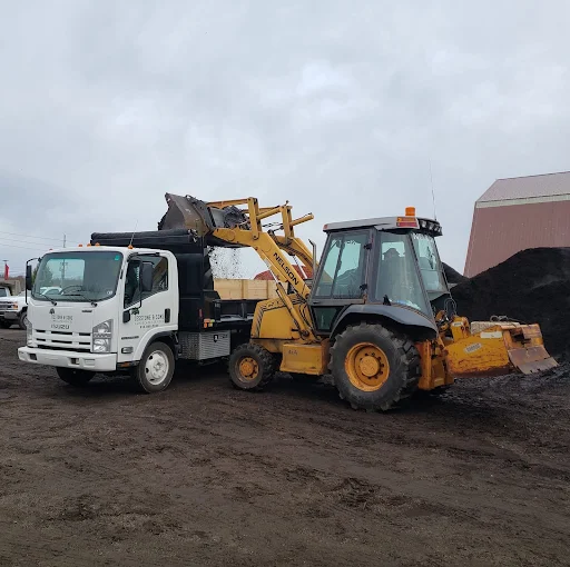 Cordovano & Sons dump truck and backhoe loading mulch at the Erie yard